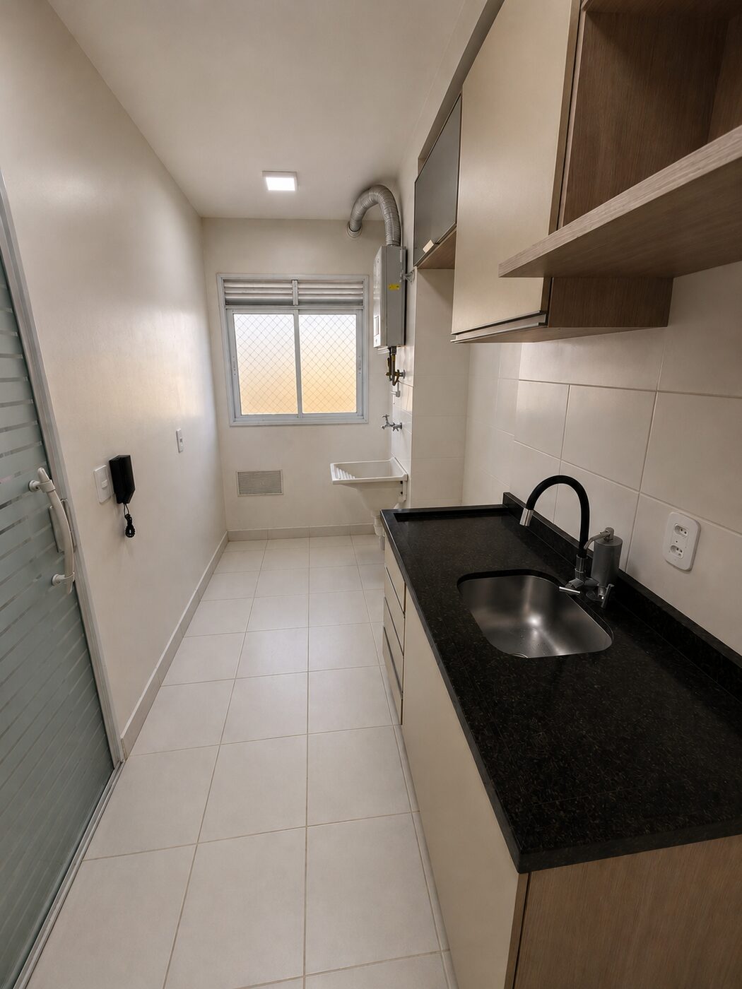 Cozinha com bancada e área de serviço separada